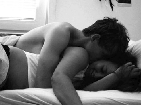 парень и девушка обнимаются в кровати.